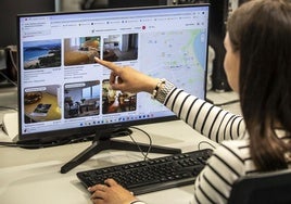 Una joven mira anuncios de pisos turísticos de Cantabria en la plataforma Airbnb.