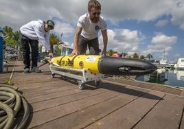 Miembros del equipo de Instituto Español de Oceanografía se disponen a trasladar el aparato tras recogerlo del agua.