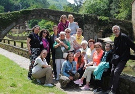 Miembros de la asociación de mayores, con la delegación polaca, ante el emblemático puente romano de Liérganes.