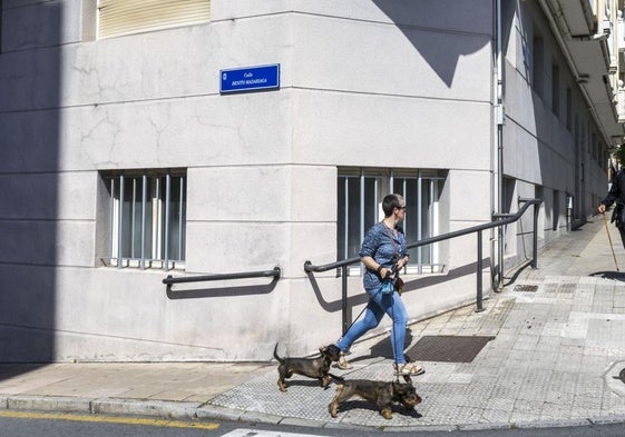 Una mujer camina junto a la nueva placa de la calle Alto de los Leoneses, que ahora se llama Benito Madariaga.