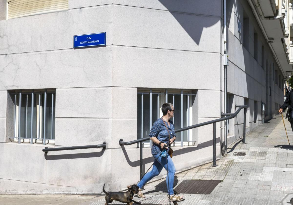 Una mujer camina junto a la nueva placa de la calle Alto de los Leoneses, que ahora se llama Benito Madariaga.