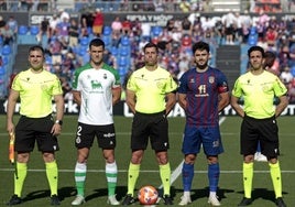 Álvaro Mantilla, con el brazalete de capitán, posa junto a Sergio Ortuño y el equipo arbitral en el Nuevo Pepico Amat.