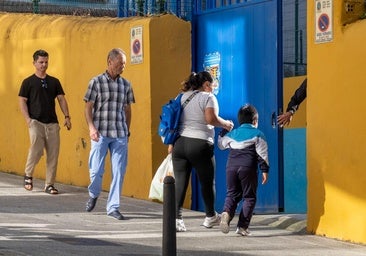 Una mujer acompaña a un niño a la entrada de un colegio en Santander durante la jornada de huelga.