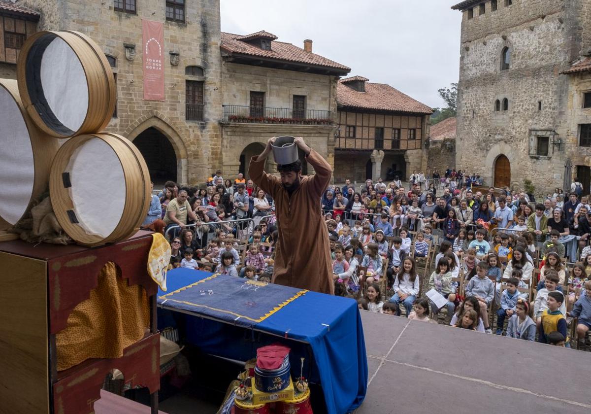 Cientos de personas, muchas familias, también turistas, atentos al espectáculo 'Mil y una', de los portugueses Caricata Teatro, con David Fariza en el escenario