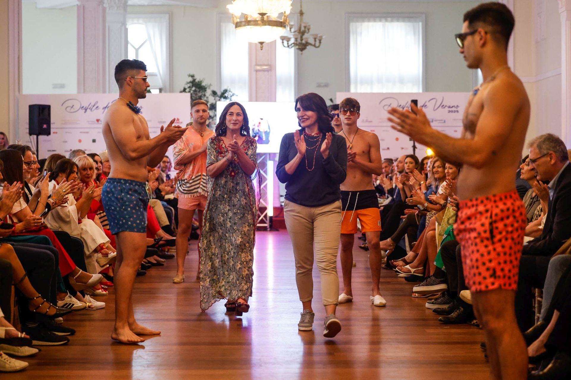 La empresaria Sandra Alonso y la diseñadora Claudia Arauz (Sardinucas) saludan al terminar el desfile masculino de moda baño.