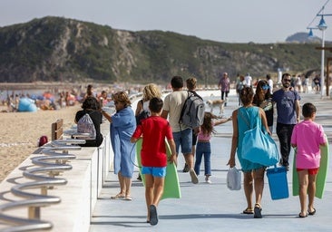 Varios grupos de personas pasean por el paseo marítimo de Suances el pasado verano.
