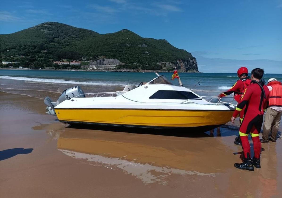 Una barca a punto de volcar con un ocupante encalla en la playa de Laredo