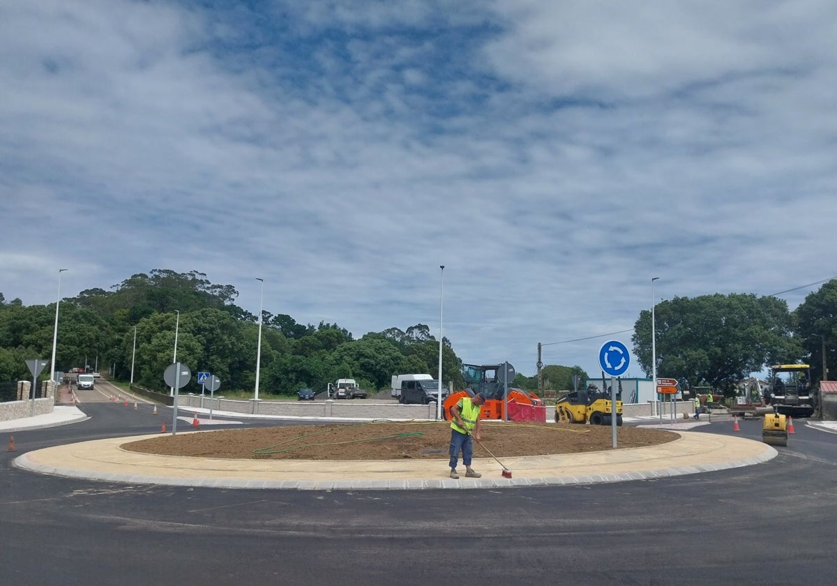 Un operario da los últimos retoques a la glorieta mientras se asfalta el vial.