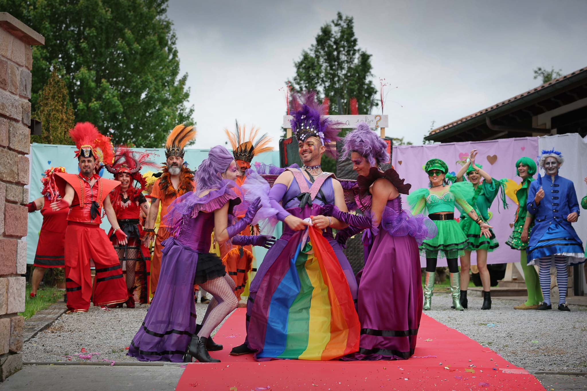 Un grupo de drag qeens desfilan sobre la alfombra roja.