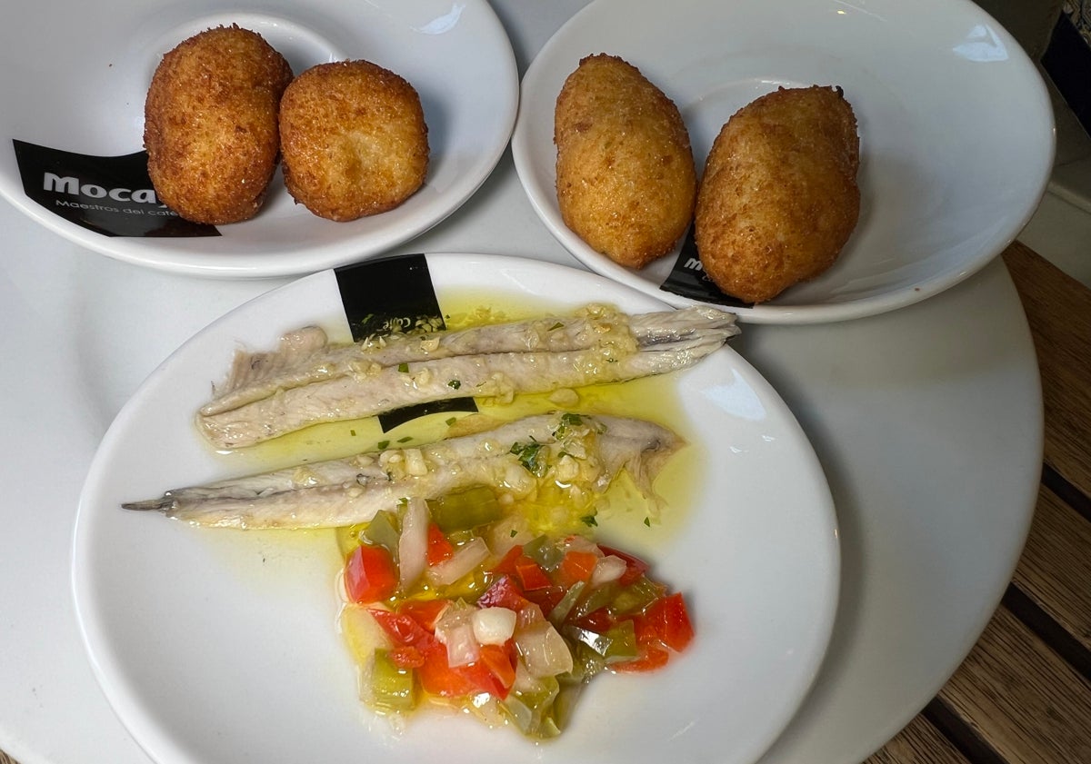Imagen principal - Croquetas caseras de jamón y bacalao y boquerones; mejillones en salsa (especialidad de la casa) y patatas con salsa , gambas al ajillo y torreznos de Soria.