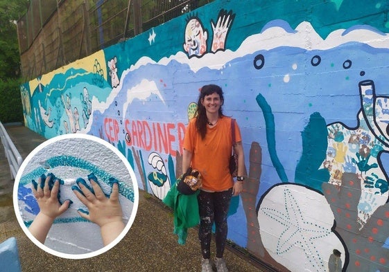 Paula Vallar posa junto al mural que ha pintado en el colegio de Santander.