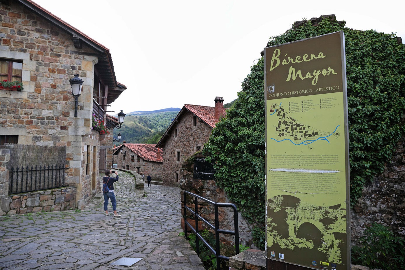 Cartel de bienvenida al pueblo de Bárcena Mayor, con las calles empedradas.