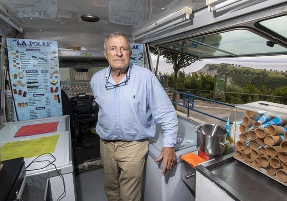 El heladero posa en su furgoneta de La Polar con todo preparado para trabajar y Mataleñas y Cabo Menor de fondo