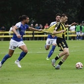 Riki controla el balón mientras Marcos le sujeta de la camiseta