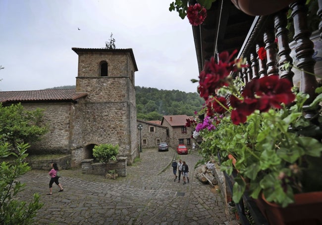 Plantas y colorido en los balcones de las casonas, con la iglesia de Santa María al fondo.
