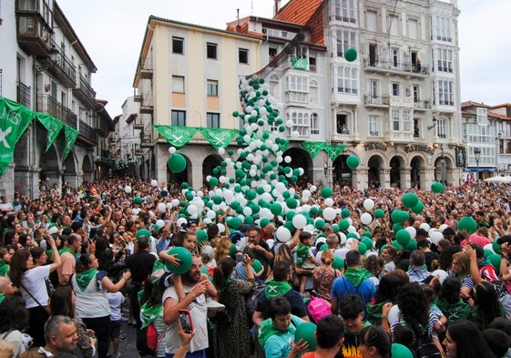 El público celebrando el inicio de las fiestas desde la balconada del Ayuntamiento con una lluvia de globos con los colores de Castro.