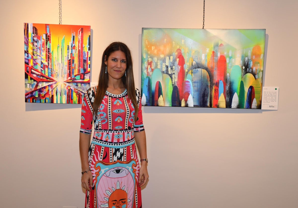 La artista junto a dos de las obras que muestra en la Casa de Cultura de Potes