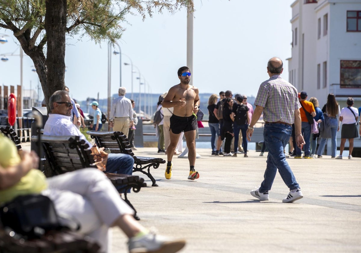 Cántabros y visitantes disfrutan del buen tiempo en el paseo marítimo de Santander.