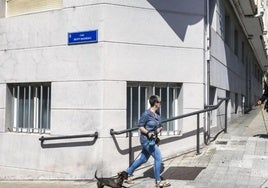 Una mujer camina junto a la nueva placa de la calle Alto de los Leoneses, que ahora se llama Benito Madariaga.