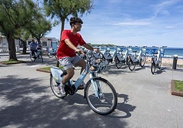 Un joven, en la zona de El Sardinero, se desplaza en una bicicleta eléctrica.