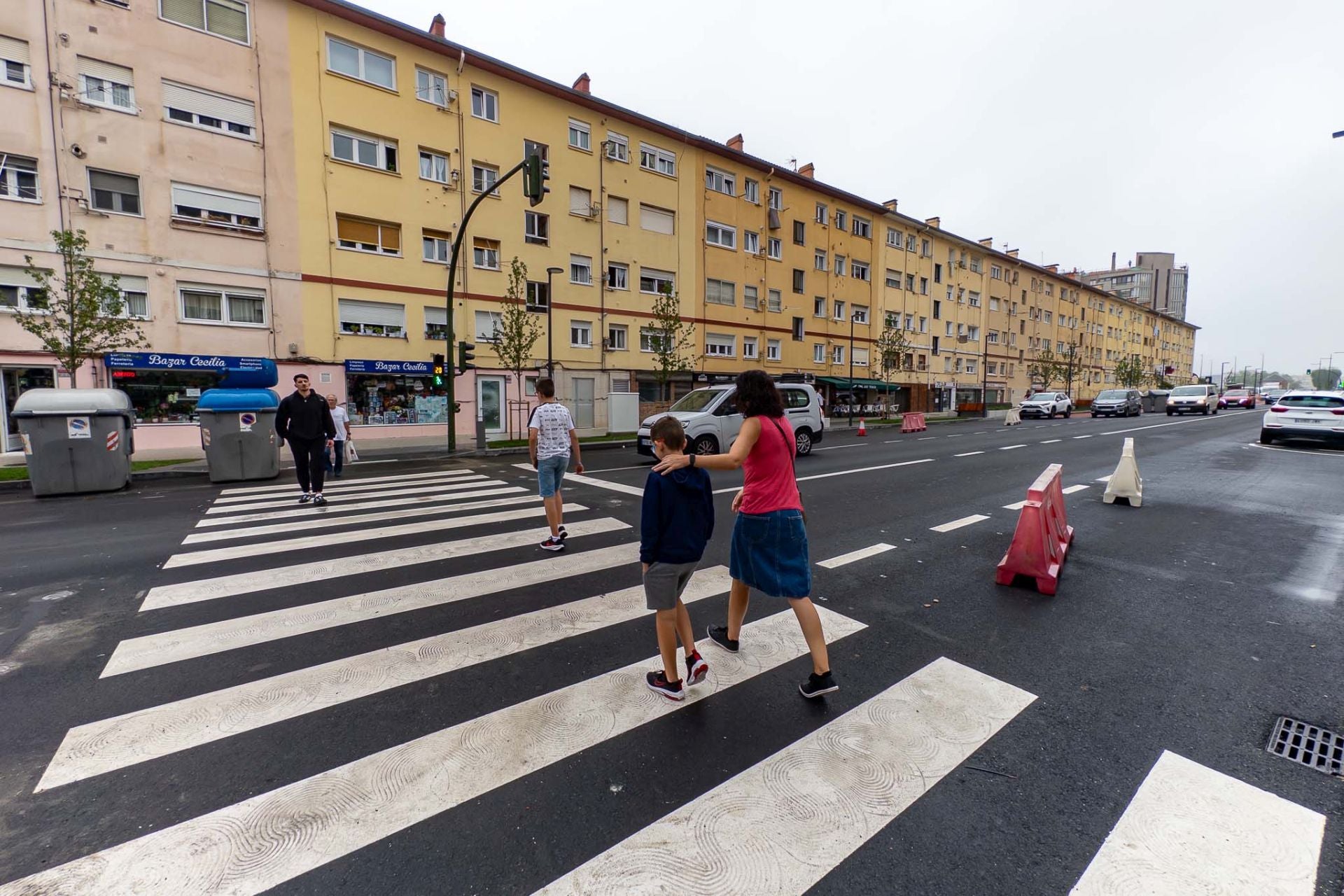 Varias personas cruzan por un paso de cebra de la zona en la que se están efectuando los trabajos. 