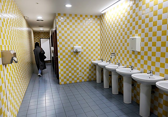 Una vecina camina por los baños, este año, en el edificio de viajeros de Torrelavega.