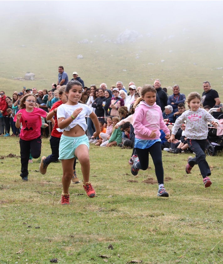 Imagen secundaria 2 - Celebración religiosa en la ermita, niñas y jóvenes del Aula de Cultura Tradicional del Valle de Camaleño, y una de las carreras de la rosca en la pradería de Campomenor