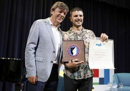 El artista asturiano Rodrigo Cuevas, galardonado con el Premio 'La Barraca' de la UIMP junto al rector, Carlos Andradas.
