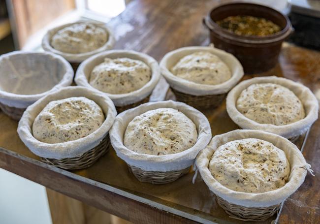 En la panadería del Cenador de Amós, en Villaverde de Pontones, se elaboran varios tipos de pan con masa madre y larga fermentación, destacando la variedad de semillas.