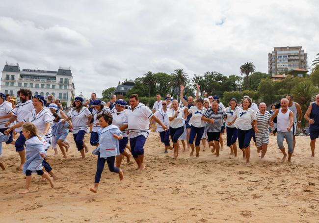 Los participantes corren a zambullirse en el agua, este domingo, a las cinco de la tarde.