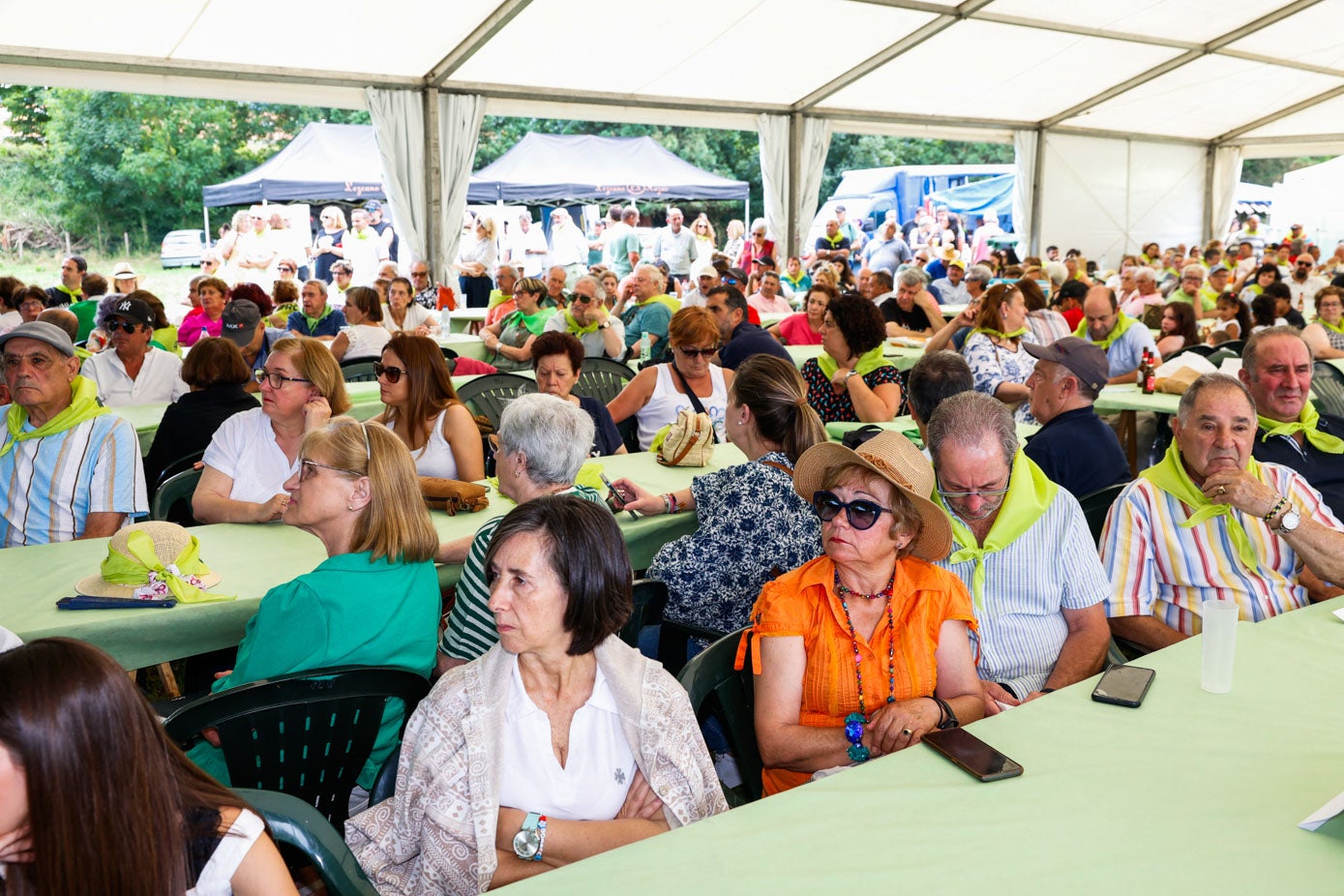 El público atiende los discursos sentado a la mesa.