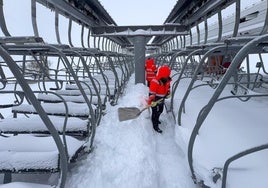 Trabajadores de Cantur limpian la nieve acumulada junto a uno de los telesilla de la estación de esquí de Alto Campoo.