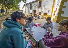 Amigos jugando a las cartas mientras hacían cola a las puertas de la plaza de toros de Santander.