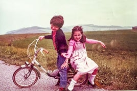 Baltasar Rodero, en la bici, con su hermana Lucía en la zona de Langre cuando eran pequeños.