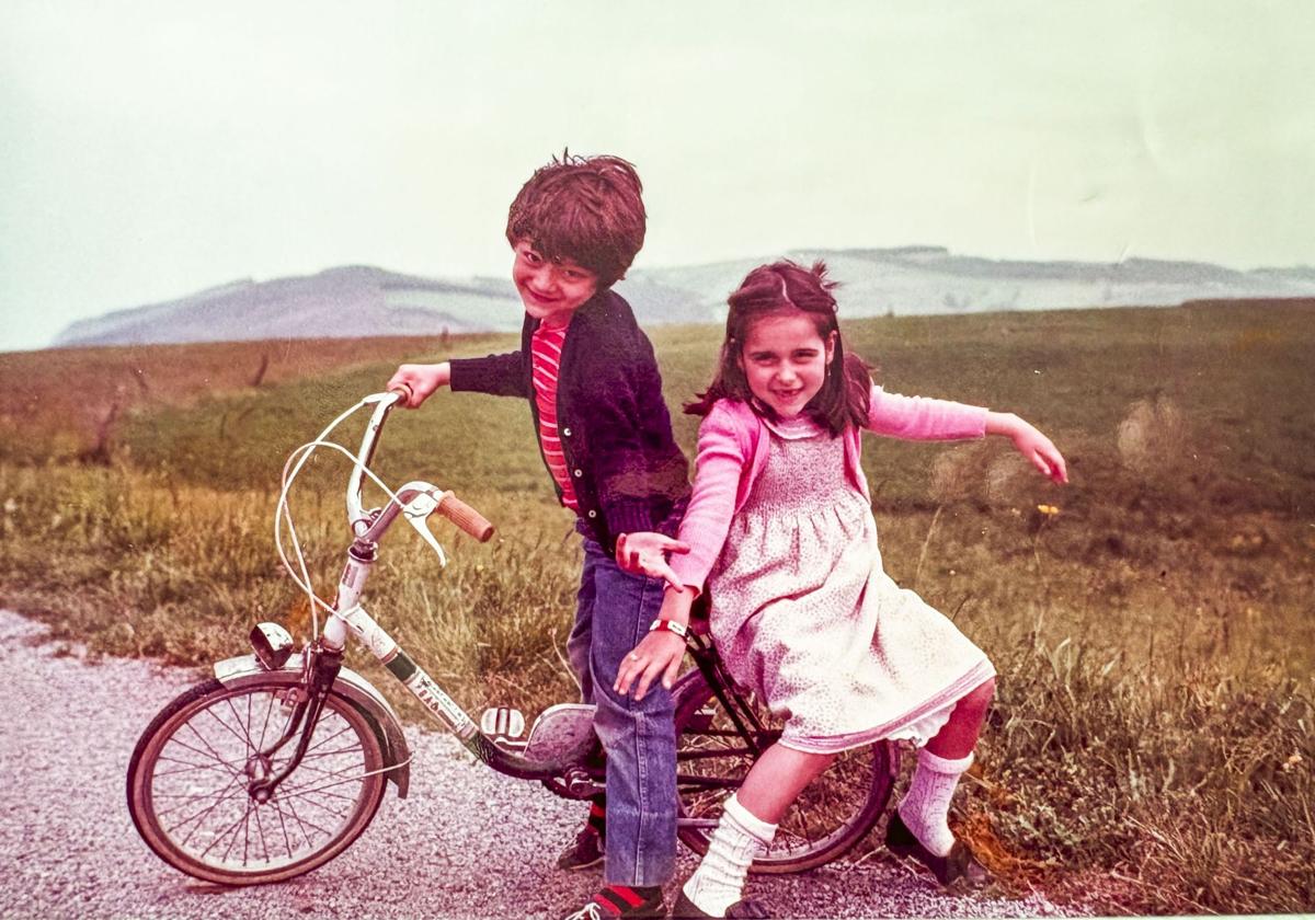 Baltasar Rodero, en la bici, con su hermana Lucía en la zona de Langre cuando eran pequeños.