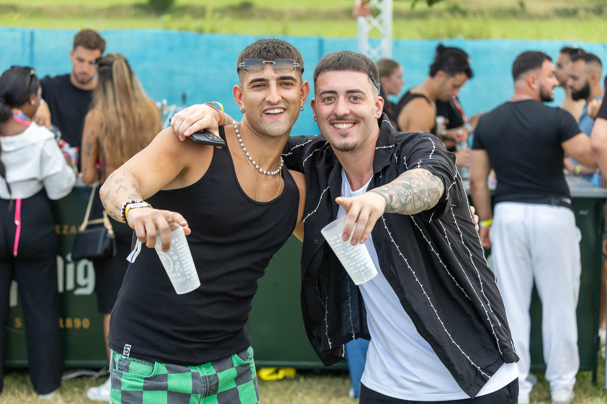 Dos asistentes posando con el vaso del festival en la mano.