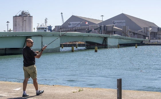 Un pescador lanza la caña en las inmediaciones del puente levadizo de Raos, averiado desde finales de 2024.