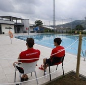 Dos socorristas junto a la piscina cerrada este domingo.