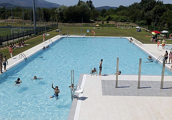 Bañistas durante un día de verano en la piscina de Tanos.