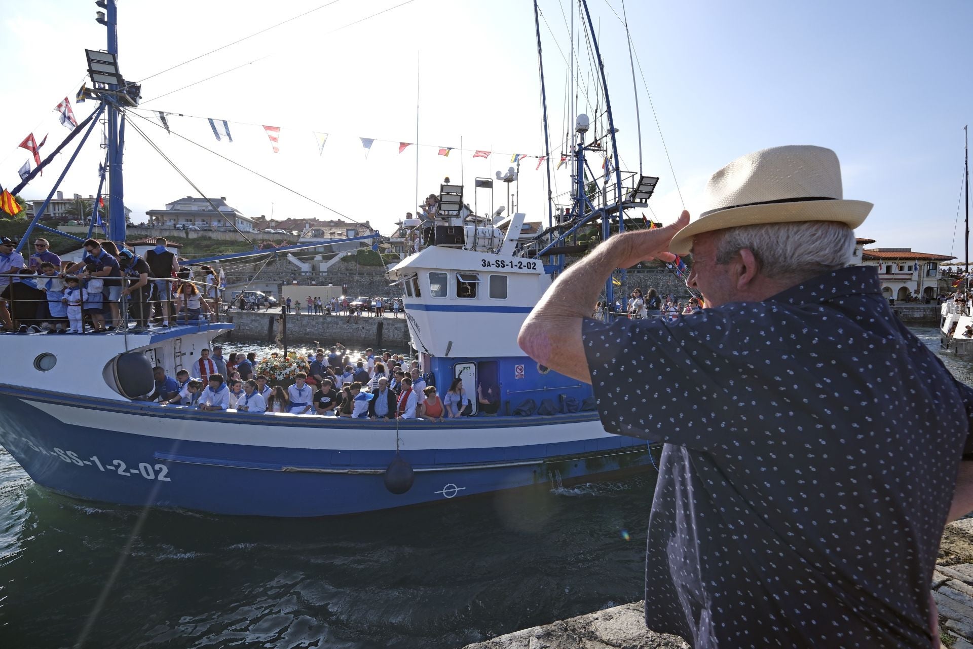 Los vecinos contemplan desde tierra la salida del barco.