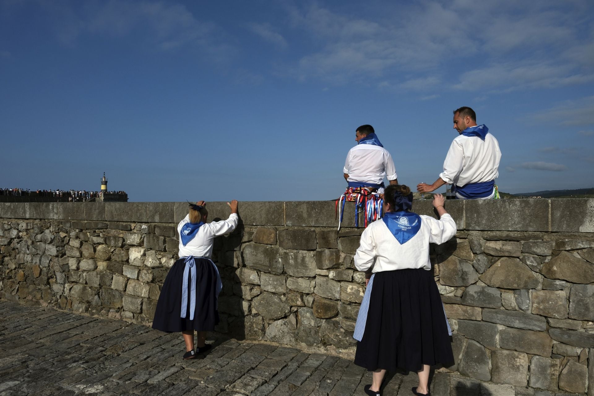 En tierra, los comillanos observan la procesión marítima.