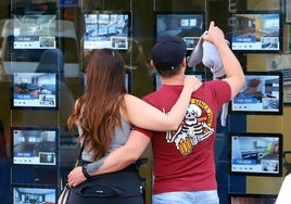Una pareja mira las ofertas en una inmobiliaria