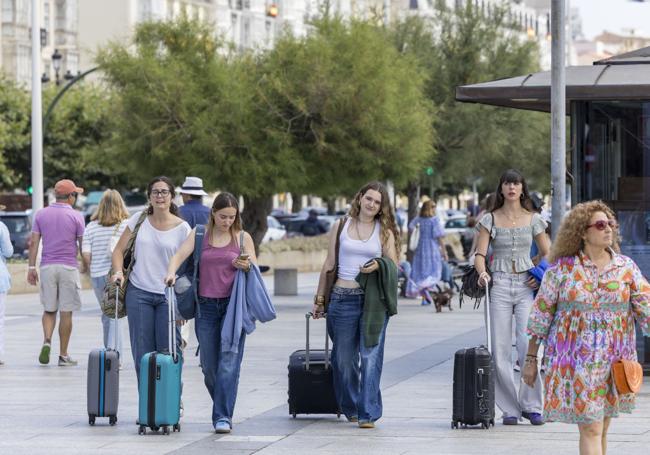 Turistas con maletas por el Paseo Marítimo de Santander.