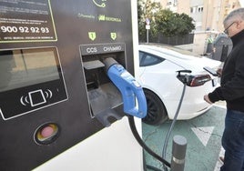 Un hombre carga su coche eléctrico en un punto habilitado.