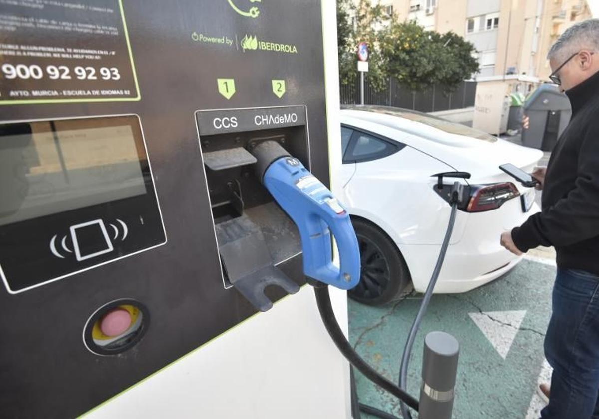 Un hombre carga su coche eléctrico en un punto habilitado.