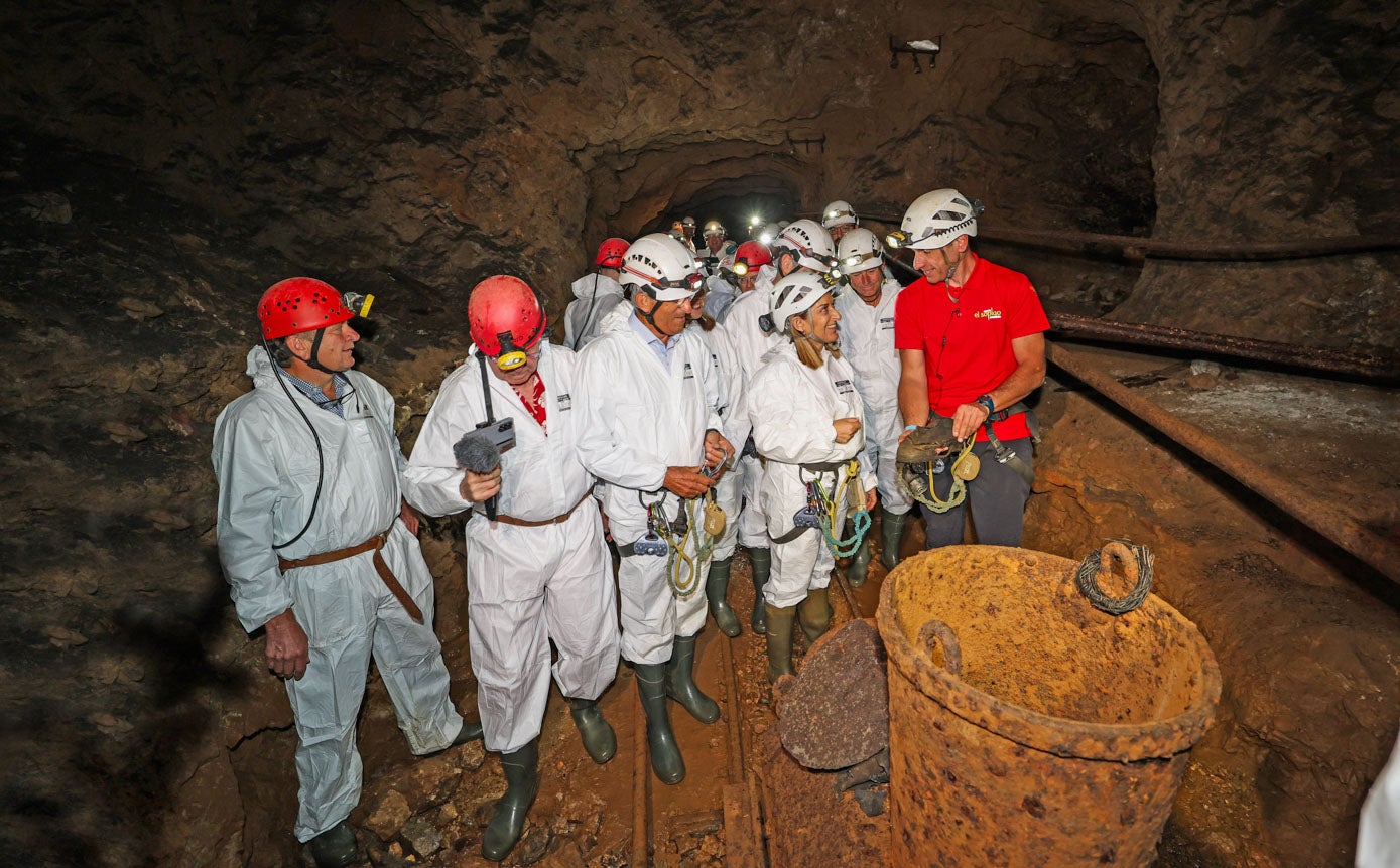 La presidenta de Cantabria María José Sáenz de Buruaga atiende las explicaciones de los guías de la cueva.