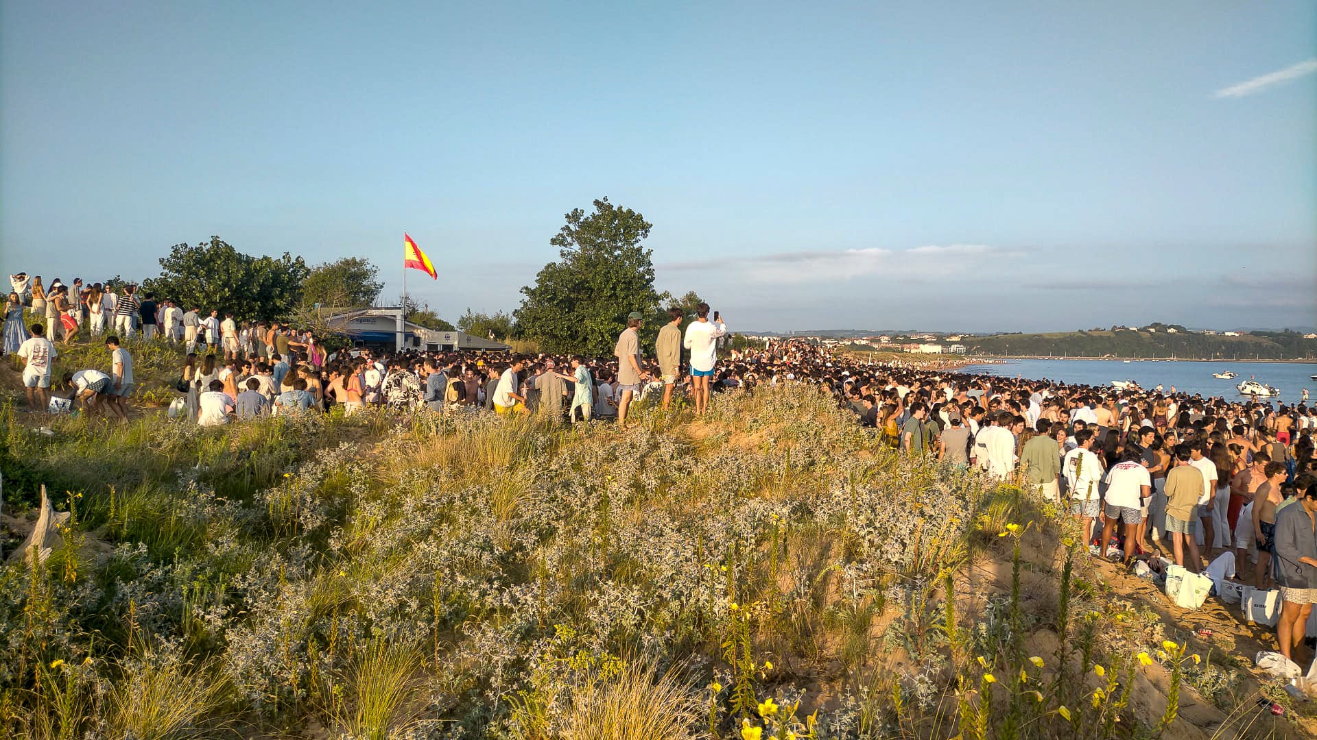Arena o duna, la presencia de personas -y botellas- se reparte por todo el arenal.