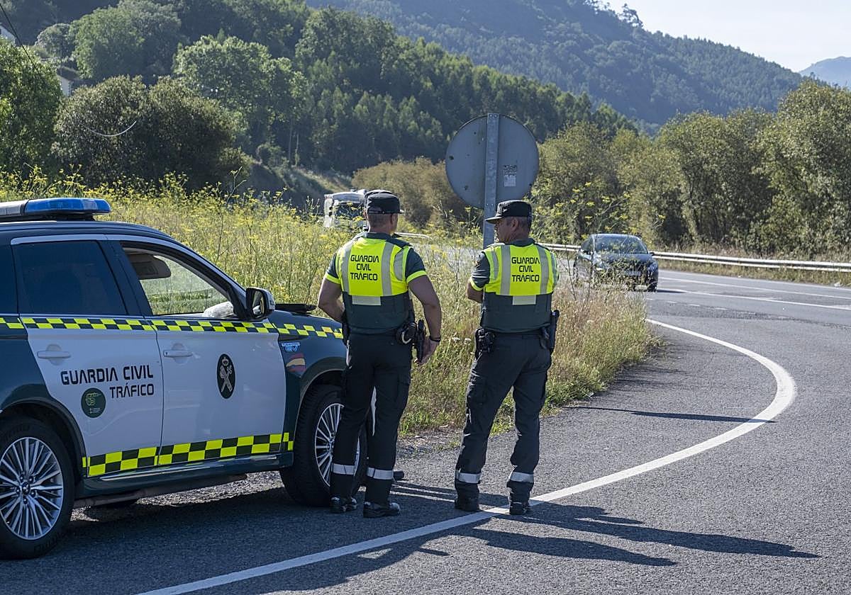 Pareja de agentes de la Agrupación de Tráfico de la Guardia Civil, en una carretera de Cantabria.