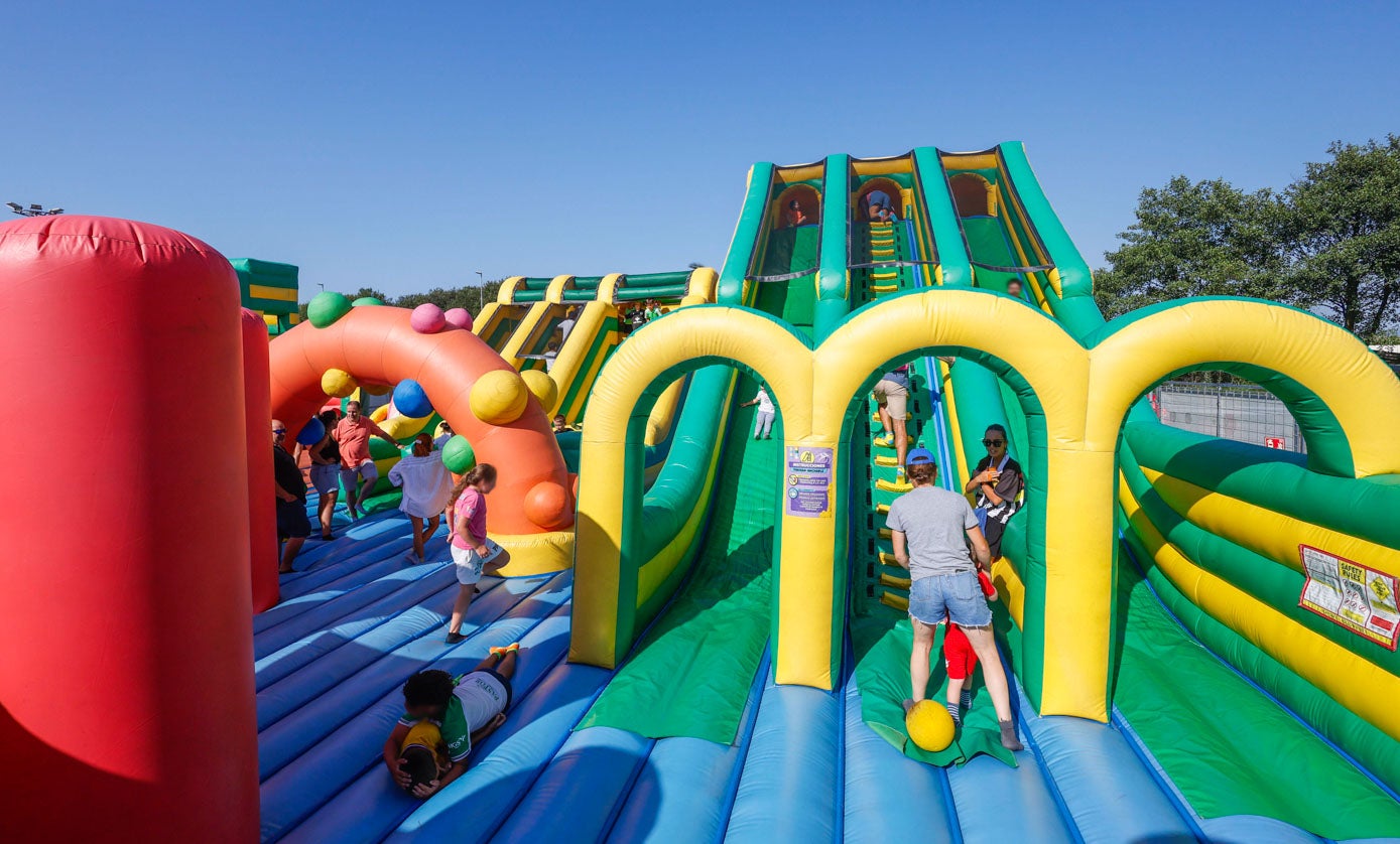Niños se deslizan, trepan y sortean obstáculos en los coloridos hinchables