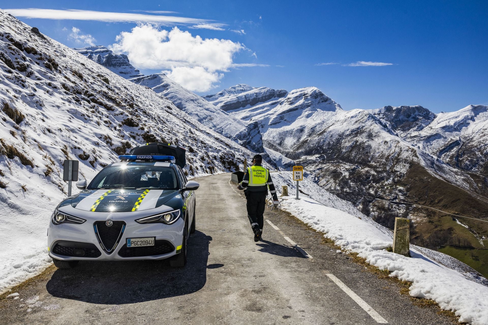 Un guardia civil camina por el punto de la carretera donde los jóvenes sufrieron el accidente.